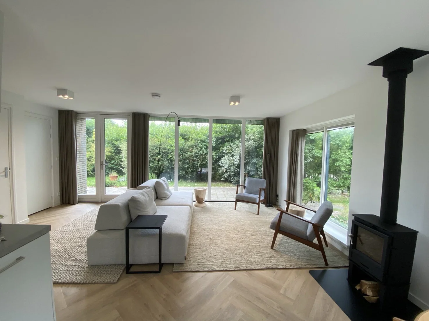 De lichte woonkamer met uitzicht op de tuin